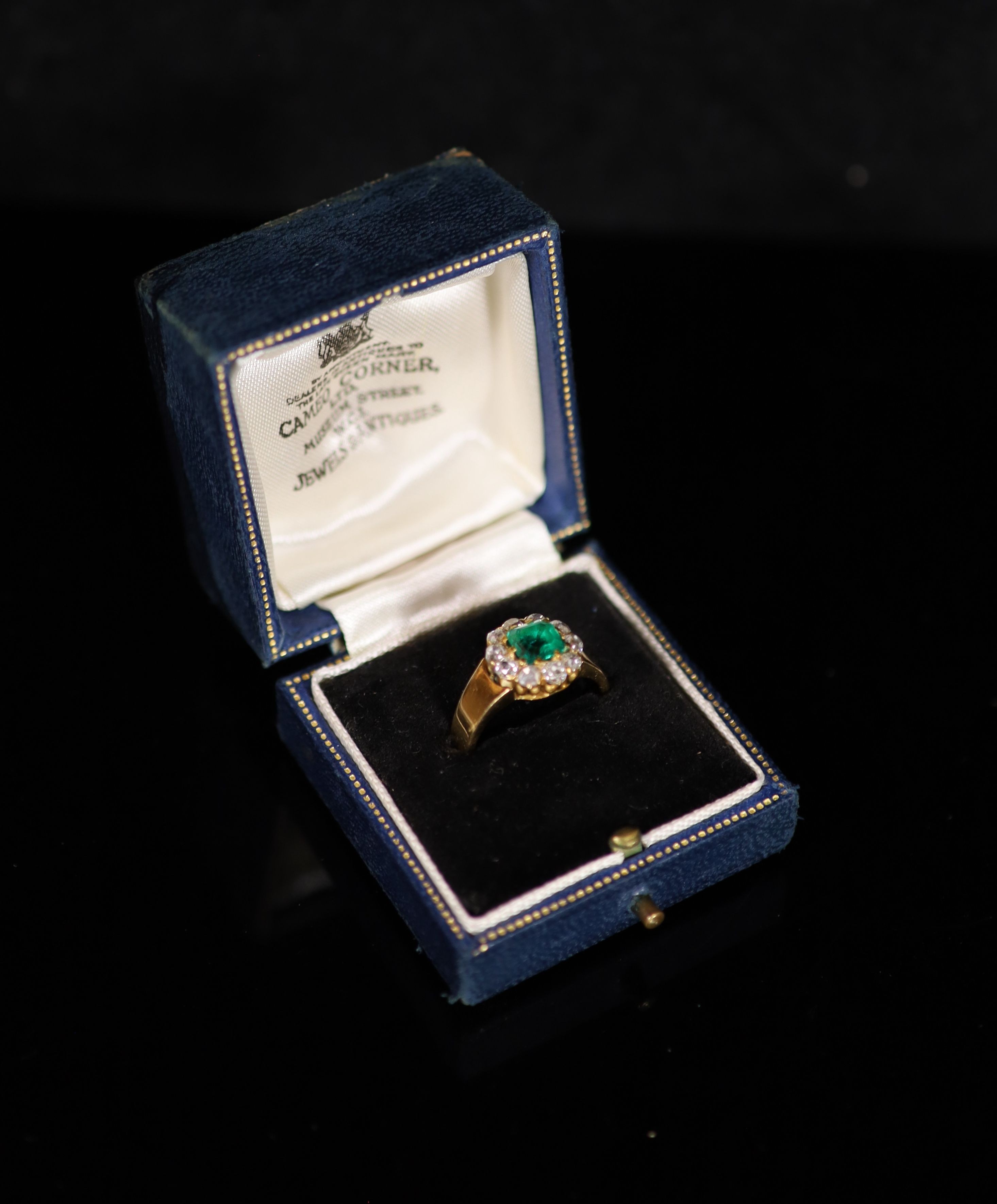 A gold, emerald and old cut diamond set circular cluster ring